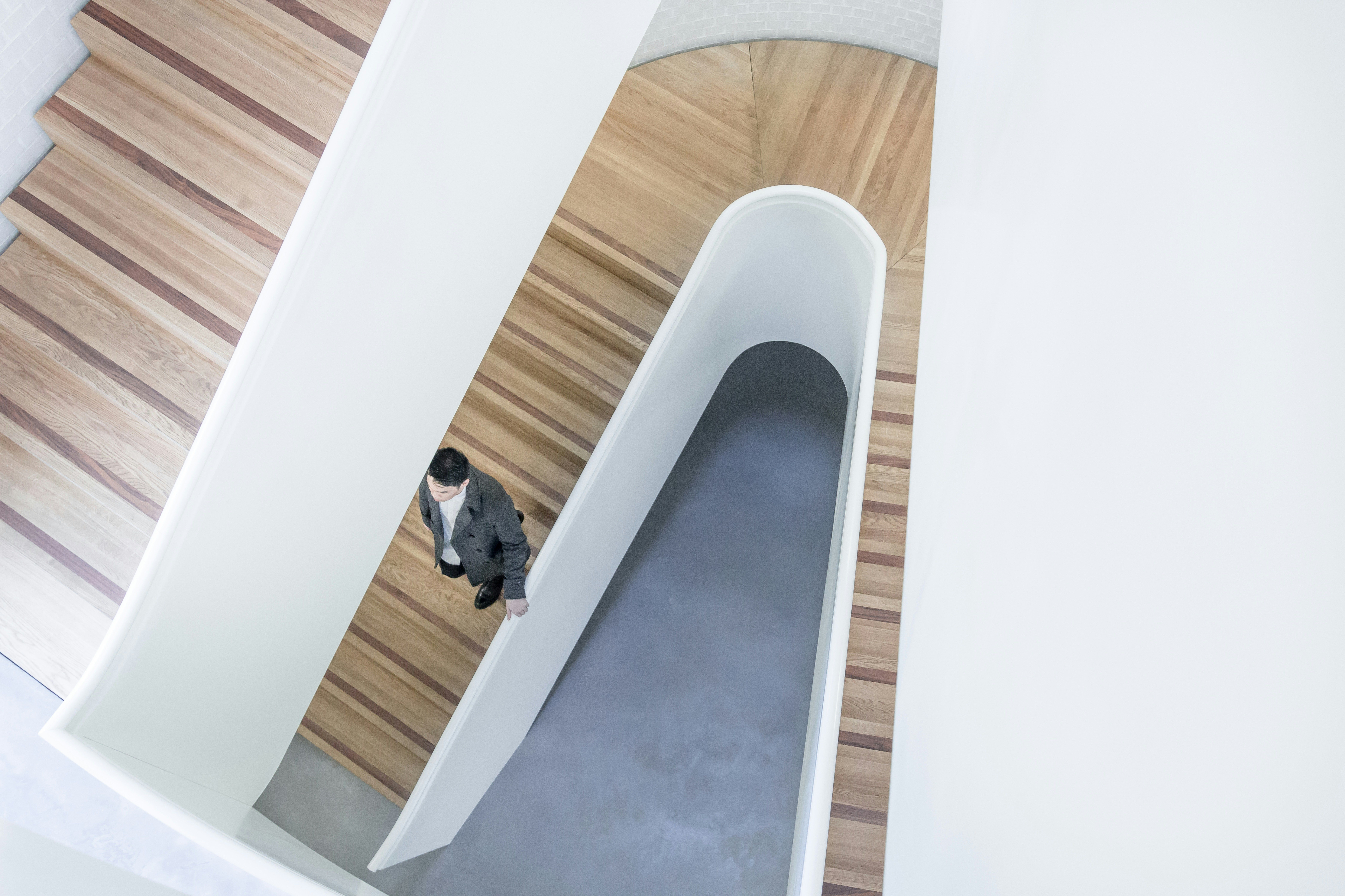Person Ascending Modern Curved Staircase for Gamified Learning Tools for Finance Education