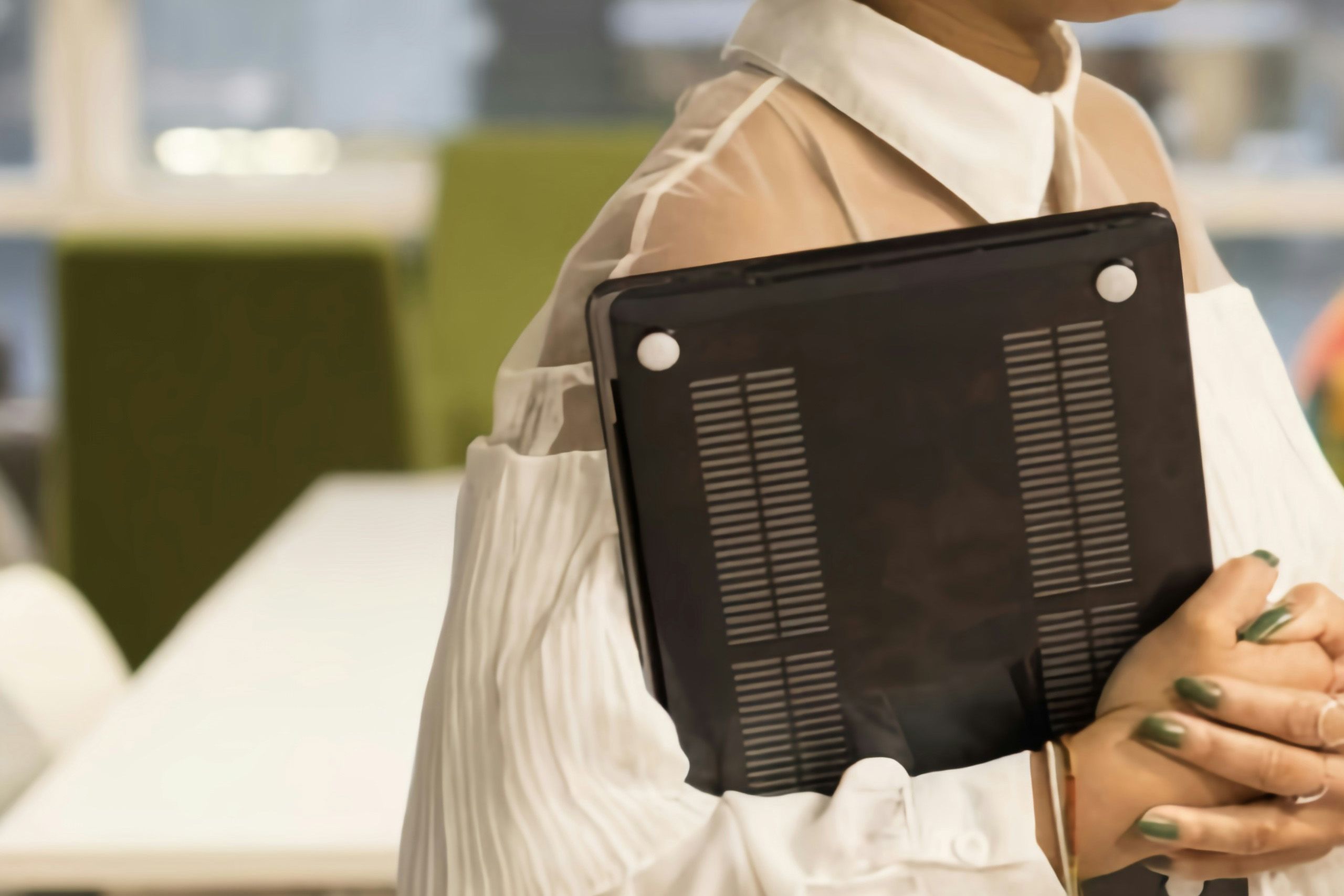 Professional woman holding laptop in office for How to Assess Finance Candidates with Real-World Scenarios